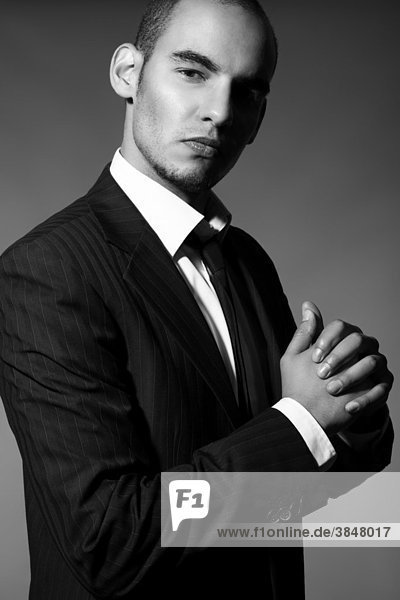 Portrait of a young man in a suit  shirt and tie  his hand clenched into a fist