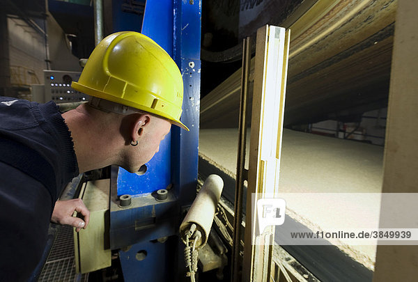 Ein Mitarbeiter beobachtet den Produktionsprozess der Spanplatten an der Presse der Produktionsstraße  Werk der Pfleiderer AG am Unternehmenssitz in Neumarkt  Oberpfalz  Bayern  Deutschland  Europa