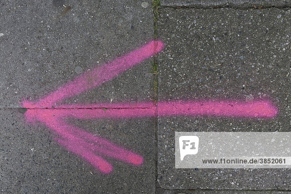 Pink arrow on asphalt