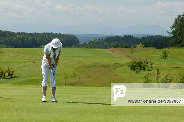 Female golfer on a golf course  Pleiskirchen  Altoetting  Upper Bavaria  Bavaria  Germany  Europe