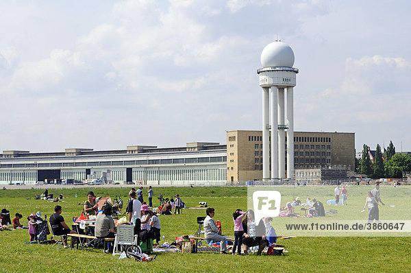 Families at a barbecueing area  in the back the radar tower of Tempelhof Airport  handed over to the public in May 2010  Tempelhofer Feld between the Tempelhof  Neukoelln and Kreuzberg districts  Berlin  Germany  Europe