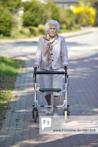 Seniorin geht mit Rollator spazieren