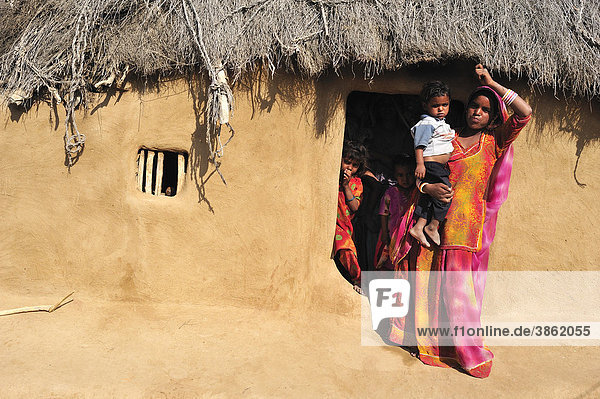 Frau im Sari mit Kleinkind am Eingang zu ihrem Wohnhaus  Wüste Thar  Rajasthan  Nordindien  Indien  Asien