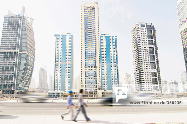 Skyline von Dubai Marina mit bewegungsunscharfen Autos und zwei Arbeitern  Dubai  Vereinigte Arabische Emirate  Naher Osten