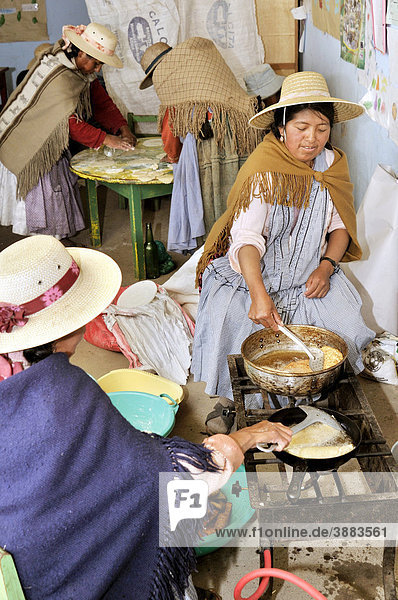 Frauen in traditioneller Kleidung der Quechua bereiten frittierte Teigtaschen zu  Bolivianisches Hochland Altiplano  Departamento Oruro  Bolivien  Südamerika