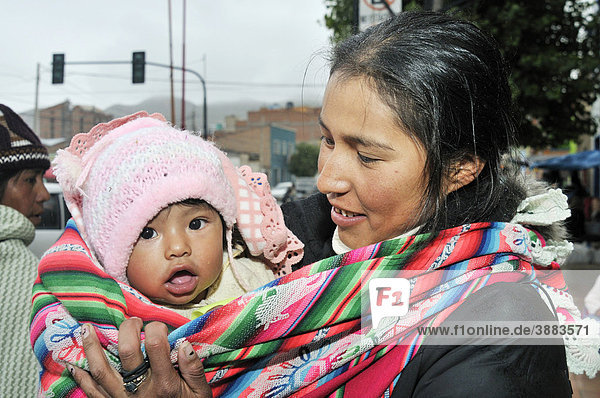 Young mother with baby in a baby-sling  Bolivian Altiplano highlands  Departamento Oruro  Bolivia  South America