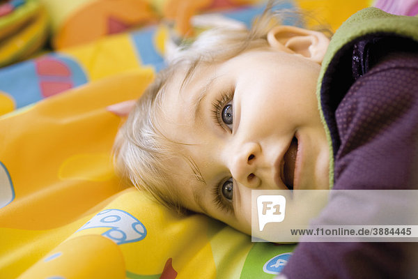 Kleinkind auf Decke liegend  Portrait