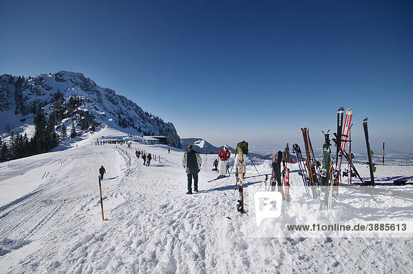 View from the Sonnenalm mountain lodge on the top station of the Kampenwandbahn ropeway  in the back Mt. Scheibenwand  in front skis in the snow and walkers on their way to the ropeway  Chiemgau  Bavaria  Germany  Europe