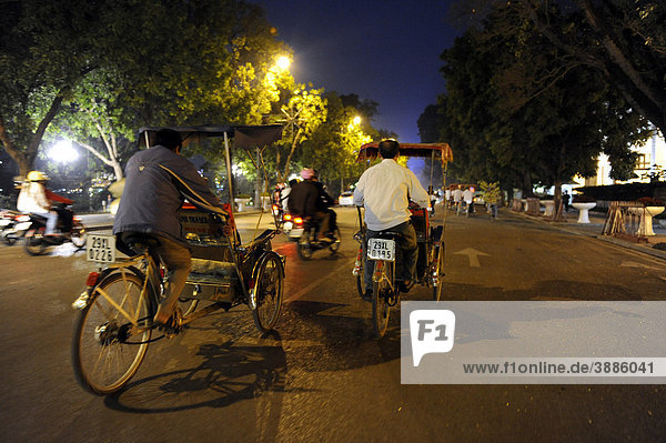 Street scene with bicycle rickshaws at night  Hanoi  North Vietnam  Vietnam  Southeast Asia  Asia