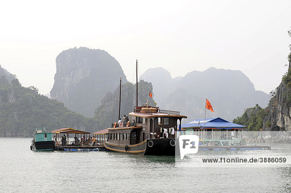 Touristenschiff ankert vor schwimmender Fischzucht  Halong Bucht  Vinh Ha Long  Nordvietnam  Vietnam  Südostasien  Asien