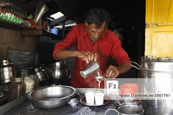 Small kitchen  man preparing tea with milk  Kumily  Kerala  India  South Asia  Asia