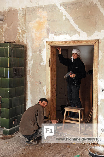 Zwei junge Leute beim Abbrennen eines alten Türrahmens in einem alten Gutshaus  Othenstorf  Mecklenburg-Vorpommern  Deutschland  Europa