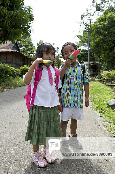 Girl and boy eating ice cream in a street in Rantepao  Sulawesi  Indonesia  Southeast Asia