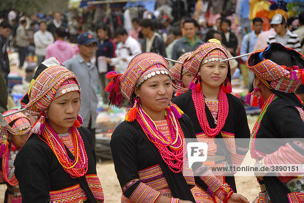 Girls of the Akha Pala ethnic group in colourful traditional dress with pink necklaces and coloured turbans with silver coins  market of Pak Nam Noi  Muang Khoua District  Phongsali Province  Laos  Southeast Asia  Asia