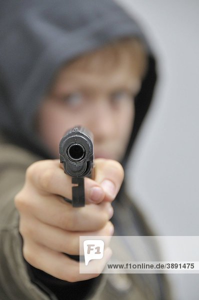 Zehnjähriger Junge mit Plastikpistole
