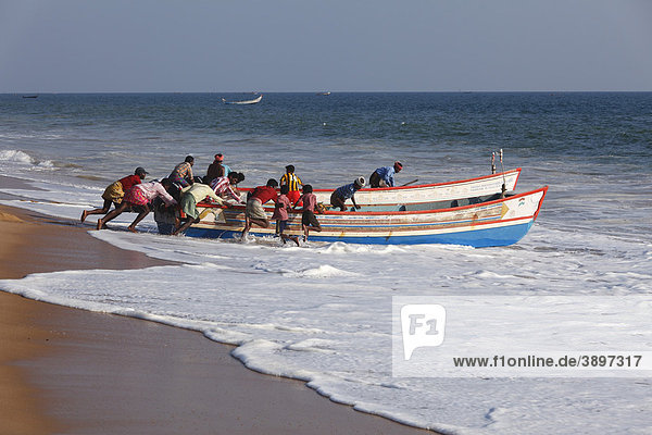 Fischer schieben Fischerboote ins Meer  Somatheeram Beach  Malabarküste  Malabar  Kerala  Südindien  Indien  Asien