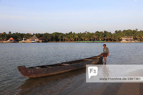 Bootsmann mit Kahn am Fluss Poovar  Backwater  Back Water  hinten Hotel Isola di Cocco Ressort  Puvar  Kerala  Südindien  Indien  Asien