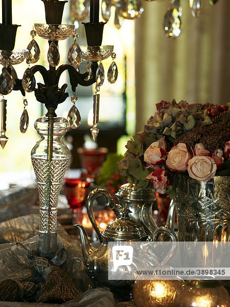 Atmospherically set table with fine silver jugs and chandelier in a sophisticated atmosphere