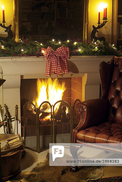 Noble fireplaces with blazing fire in a classy atmosphere  leather chair and Christmas decoration