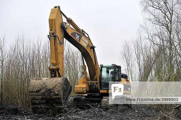 A large digger in the process of attempting to pull another smaller digger out of the mud