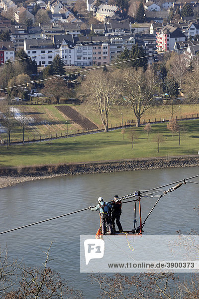 Workers in a safety cage navigate the suspension cable of a cable car which will connect the Deutsches Eck headland with the Festung Ehrenbreitstein fortress for the Bundesgartenschau Federal Garden Show 2011  Koblenz  Rhineland-Palatinate  Germany  Europe