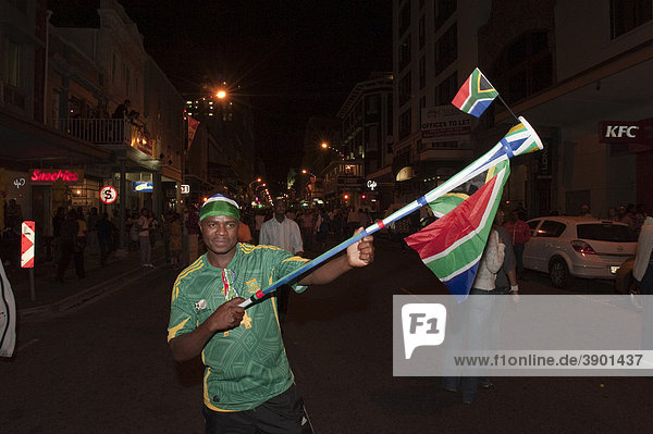 South African soccer fan with flag and Vuvuzela blowing horn to celebrate until deep into the night  Long Street  Cape Town  South Africa