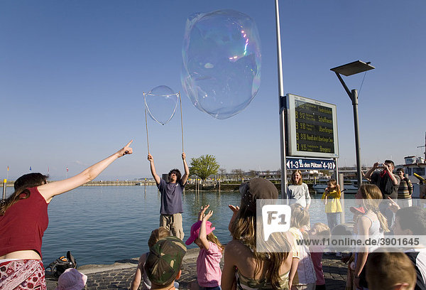 Street artist making large soap bubbles  children  show  port  Konstanz  Baden-Wuerttemberg  Germany  Europe