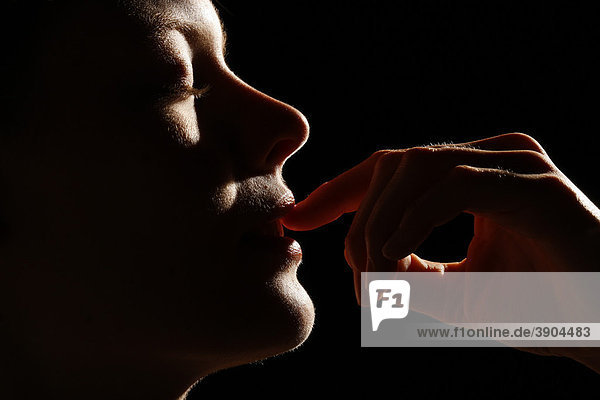Junge Frau mit Finger an den Lippen  Profil mund