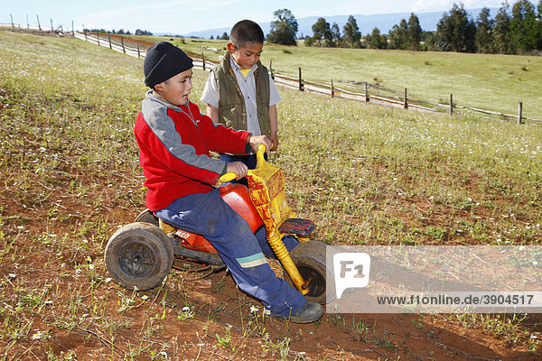 Two boys playing with a tricycle  Mapuche Indians  near ConcepciÛn  Southern Chile  Chile  South America