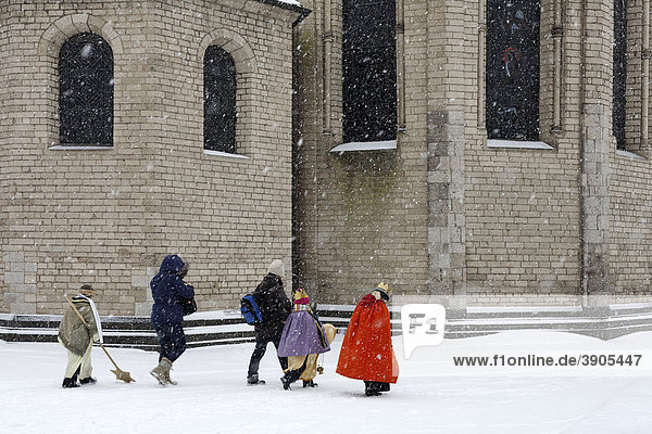 Sternsinger gehen im Schneetreiben vor der Basilika St. Suitbertus  Düsseldorf-Kaiserswerth  Nordrhein-Westfalen  Deutschland  Europa