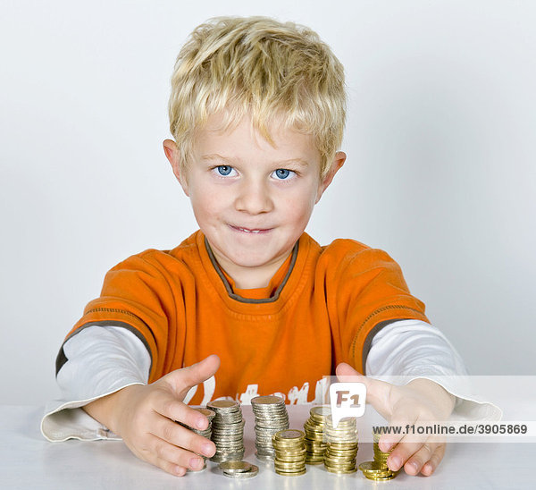 Boy  5-years old  stacks of money  symbolic picture for making profit
