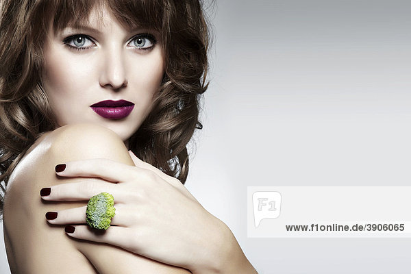 Portrait of a young woman with a broccoli ring  jewelry  with a seductive look mouth