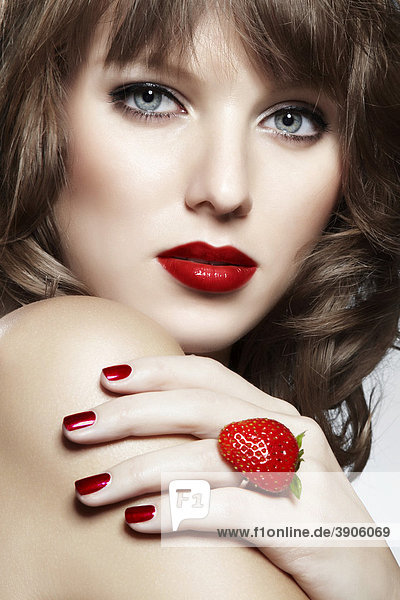 Portrait einer jungen Frau mit einem Erdbeer-Ring  Schmuck  mit einem verführerischen Blick mund