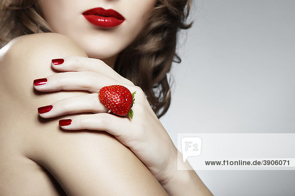 Junge Frau mit einem Erdbeer-Ring  Schmuck mund