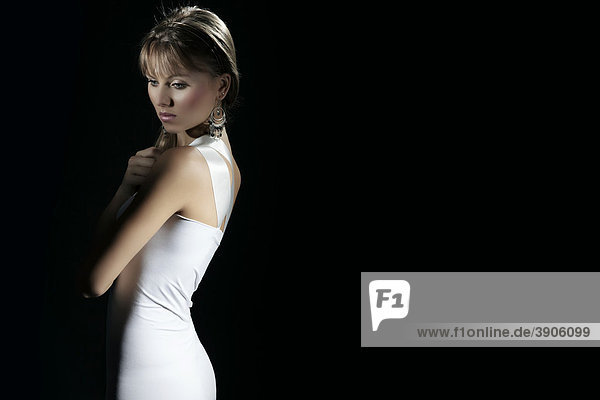 Junge Frau im weißen Kleid vor Schwarz  Ohrring  Fashion