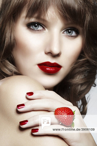 Portrait of a young woman wearing a ring made from a strawberry with a seductive look  jewellery