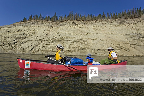 Familie mit kleinem Jungen in einem Kanu  Rudern  Kanufahren auf dem Teslin River Fluß  hohes eingeschnittenes Flussufer  Erosionslandschaft  Yukon Territory  Kanada
