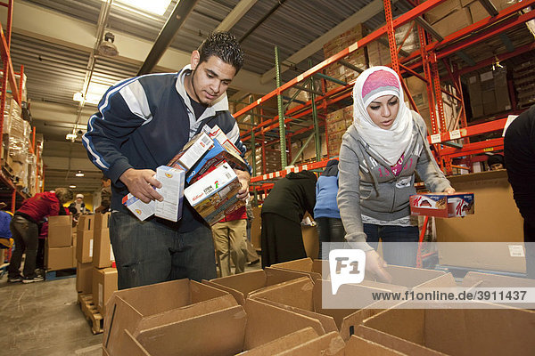 Arabisch-amerikanische Teenager helfen als Freiwillige als Teil des Martin Luther King Day of Service-Projekts in der Gleaners Community Food Bank Tafel Nahrung für Bedüftige abzupacken  Detroit  Michigan  USA