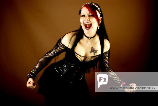 Woman  dressed in a Gothic style  screaming with fists clenched