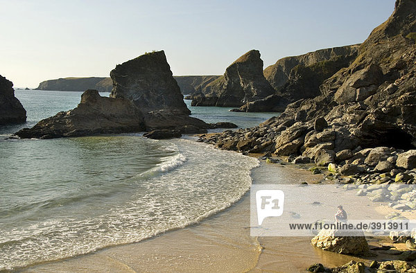 Strand  Felsformation  Frau sitzt auf Felsen  Bedruthan Steps  Cornwall  Südengland  England  Großbritannien  Europa
