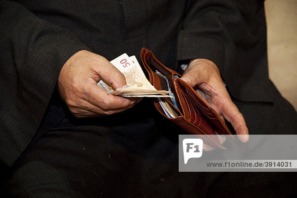 Arabischer Mann füllt sein Portemonnaie