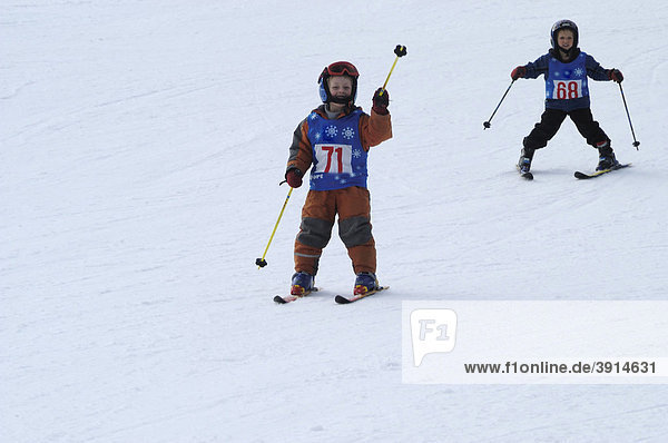 Kinder beim Skifahren mit Startnummern
