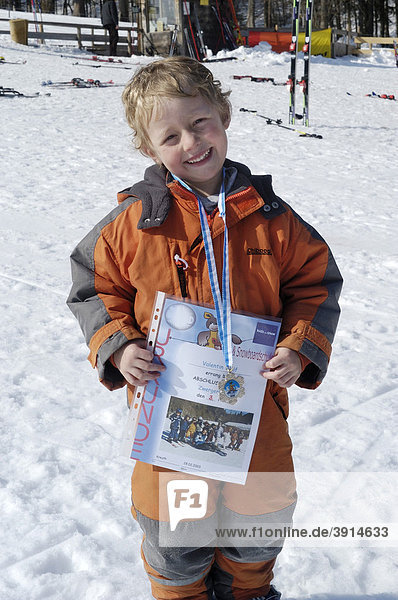 Kleiner Junge  5 Jahre  freut sich über seine Siegerurkunde nach dem Skirennen