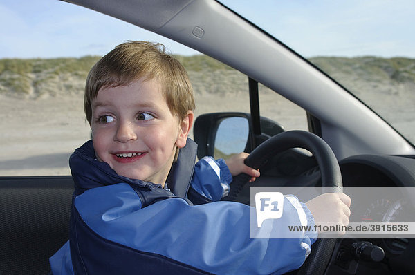 Little boy  2 years  sitting at the wheel of a car