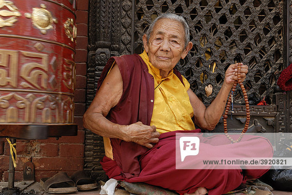Nonne mit Gebetskette im Bodhnath Tempel  Kathmandu  Nepal  Asien