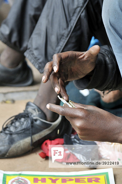 Straßenkinder konsumieren Drogen  Marihuana  Junge baut einen Joint  in Hillbrow  Johannesburg  Südafrika  Afrika