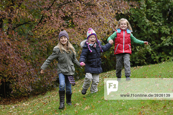 Three friends  4 to 7 years  playing and running around in autumn