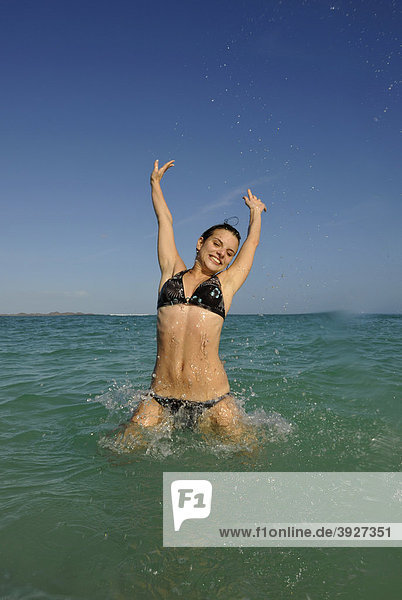 Junge Frau im Meer  Symbolbild Lebensfreude  Playa Bajo Negro  Corralejo  Fuerteventura  Kanarische Inseln  Kanaren  Spanien  Europa