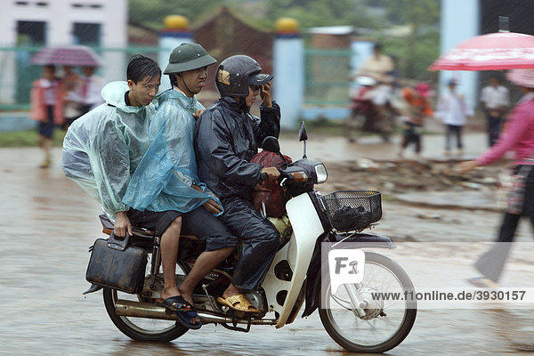 Rainproof moped riders in Dliya in the Dolisa district  Daklak province  Vietnam  Southeast Asia