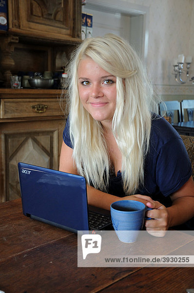 Blondes Mädchen mit einem Laptop in einem Wohnzimmer